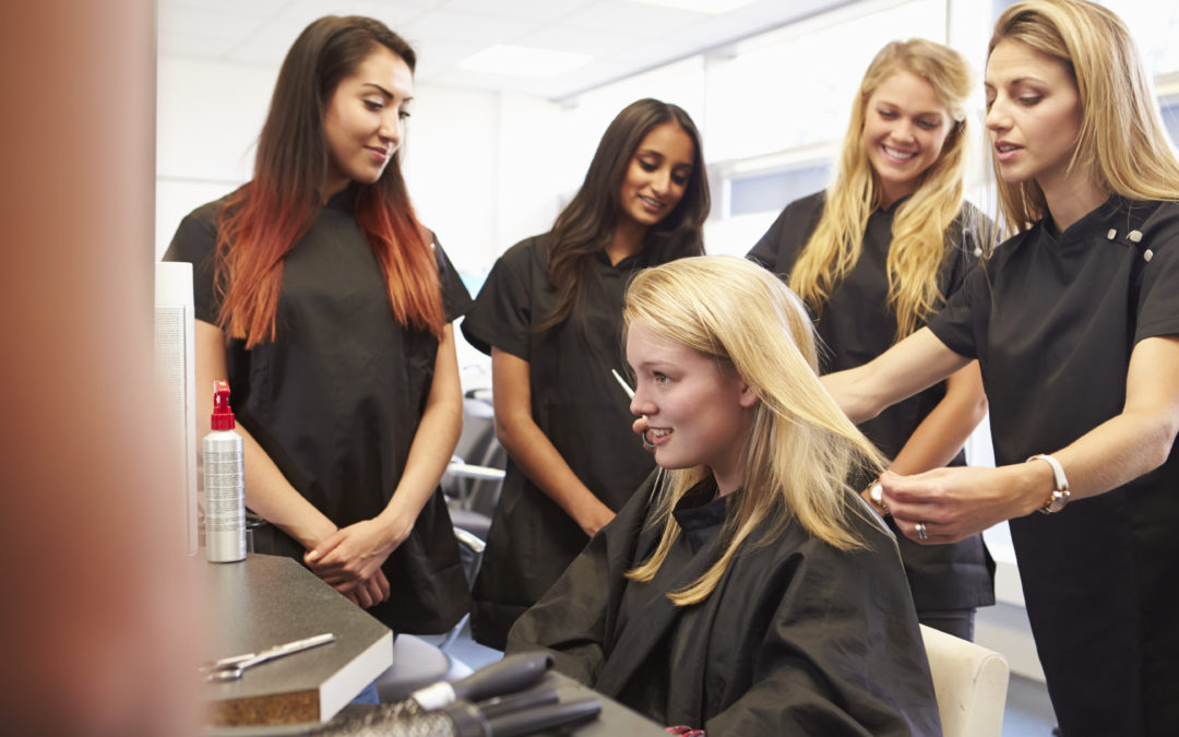 Teacher Helping Students Training To Become Hairdressers